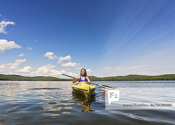 Junge Frau beim Kajakfahren auf einem See
