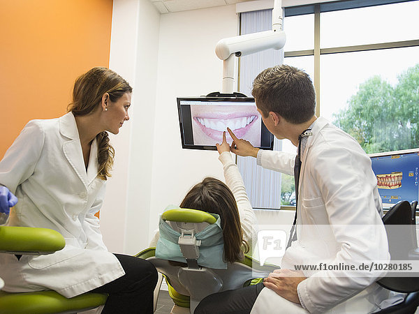 Dentists and patient looking at screen
