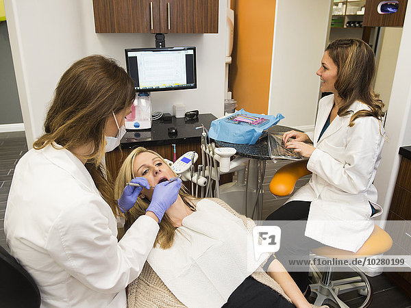 Zahnärzte und Patienten in der Praxis eines Zahnarztes