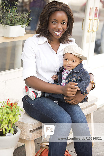 Porträt einer lächelnden Frau mit ihrem Sohn (12-17 Monate)
