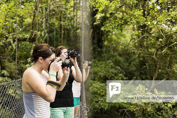 Young women photographing in forest