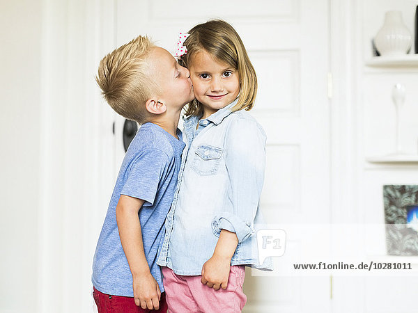 Kleiner Junge (4-5) küsst Schwester (4-5)