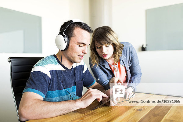 Mann zeigt Frau seine Musik auf dem Smartphone