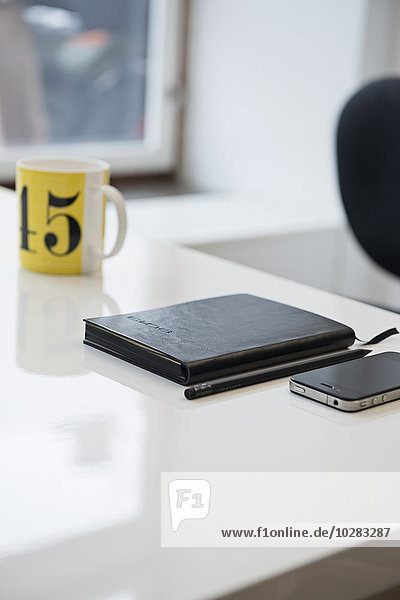 Tagebuch und Mobiltelefon auf dem Schreibtisch