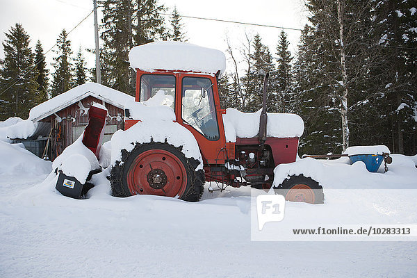 Traktor mit Schnee bedeckt