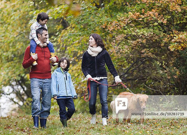 Family with dog walking through forest