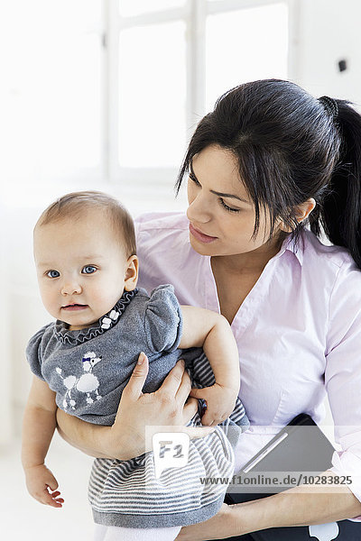 Businesswoman with baby girl in office