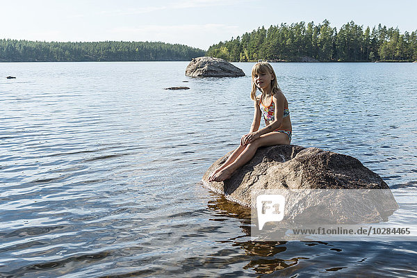 Girl on rock in lake