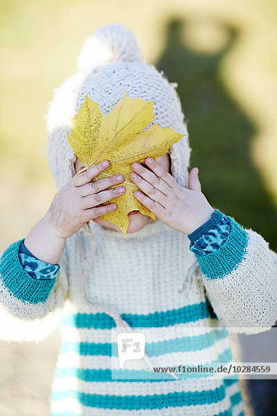 Kleinkind mit Herbstblatt
