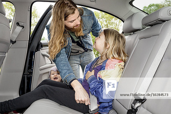 Father checking daughters safety belt