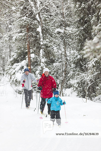 Junge beim Skifahren mit Eltern