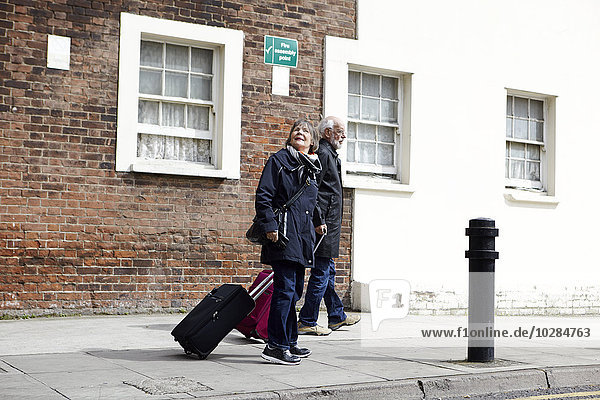 Älteres Paar beim Spaziergang mit Gepäck