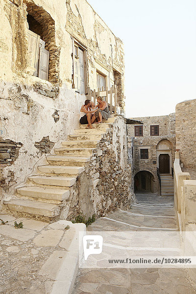 Family sitting on steps of old building