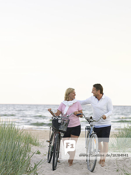 Couple with bicycles on beach