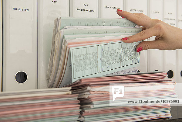 Close-up of nurse's hand searching medical records  Munich  Bavaria  Germany
