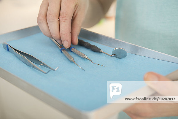 Zahnmedizinische Fachangestellte hält ein Tablett mit zahnmedizinischen Instrumenten in der Zahnklinik  München  Bayern  Deutschland