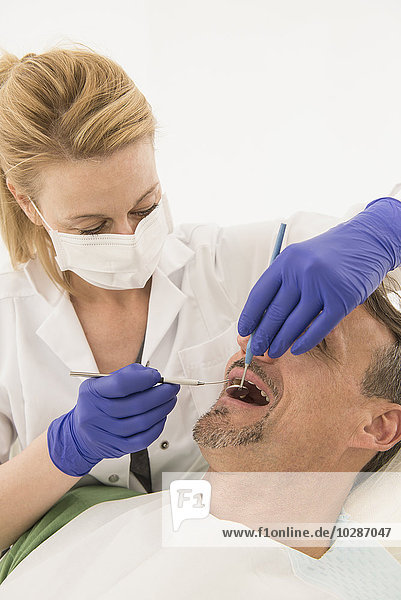 Zahnärztin bei der Untersuchung eines Patienten  München  Bayern  Deutschland