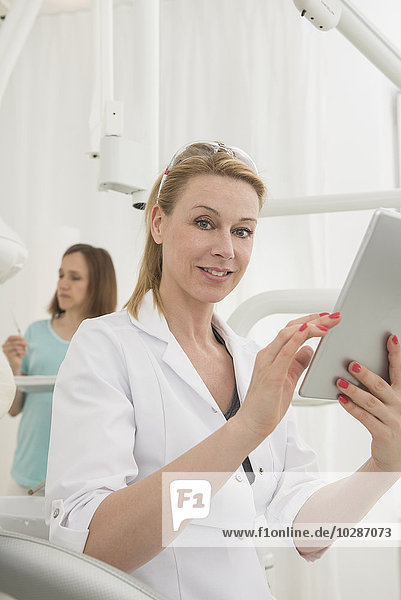 Female dentist using digital tablet in clinic  Munich  Bavaria  Germany