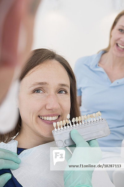 Dentist and patient selecting teeth colour  Munich  Bavaria  Germany