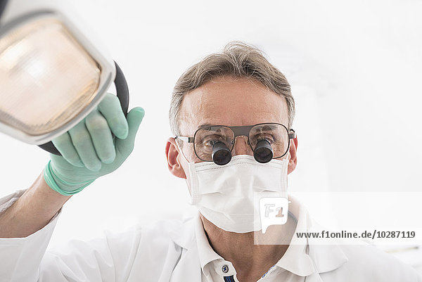 Close-up of male dentist wearing magnifiers on eyeglasses  Munich  Bavaria  Germany