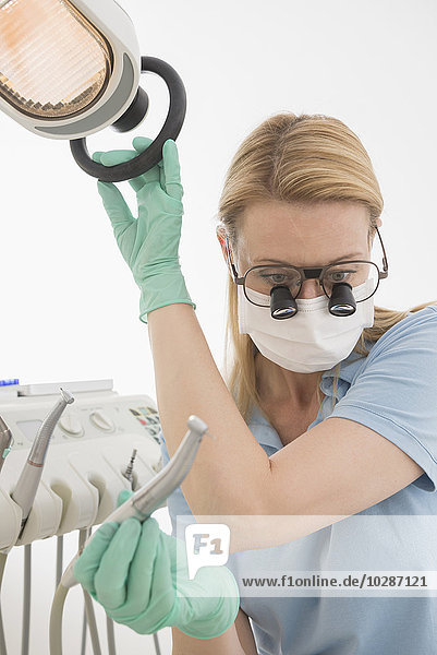 Close-up of female dentist holding dental drill with magnifiers on eyeglasses  Munich  Bavaria  Germany