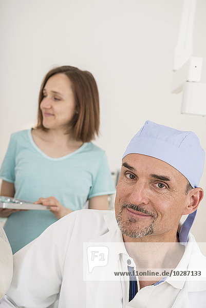 Portrait of dentist with dental assistant in background  Munich  Bavaria  Germany