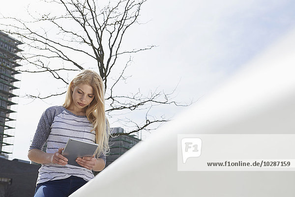Teenage girl using a digital tablet in a playground  Munich  Bavaria  Germany