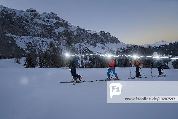 Skitourengeher beim Klettern auf einem verschneiten Berg mit Stirnlampen  Gröden  Trentino-Südtirol  Italien