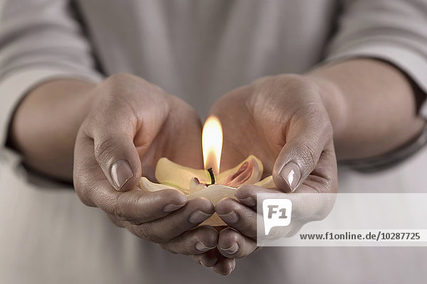 Frau hält brennende Kerze in den Händen  Bayern  Deutschland