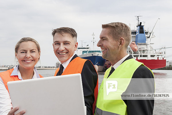 Porträt von Geschäftsleuten  die am Laptop im Hafen arbeiten  Hamburg  Deutschland