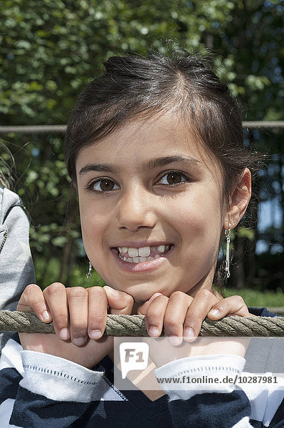 Girl smiling on rope bridge  Munich  Bavaria  Germany