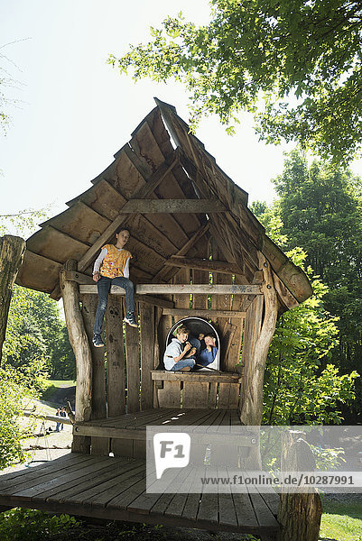 Zwei Jungen und ein Mädchen auf einem Häuschen auf dem Abenteuerspielplatz  München  Bayern  Deutschland
