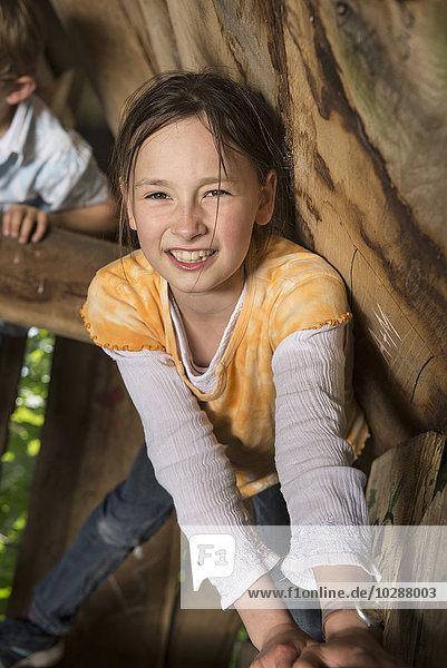 Mädchen klettert auf einem Baumhaus auf einem Spielplatz  München  Bayern  Deutschland