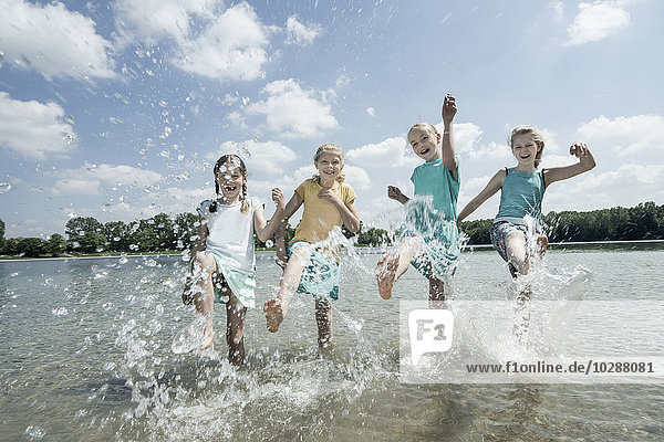 Group of friends splashing water in the lake  Bavaria  Germany