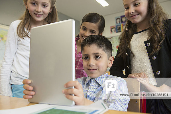 School children using a digital tablet in classroom  Munich  Bavaria  Germany