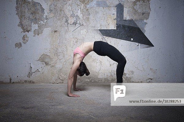 Mittlere erwachsene Frau beim Üben der Brückenhaltung im Yogastudio  München  Bayern  Deutschland