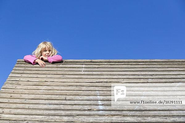 Mädchen klettert auf Holzhaus  Kiel  Schleswig-Holstein  Deutschland  Europa
