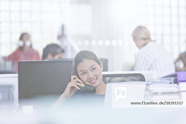 Lächelnde Geschäftsfrau am Telefon im Büro