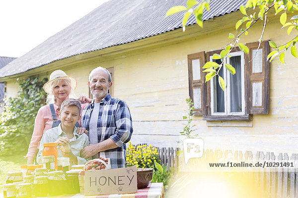 Portrait stolze Großeltern und Enkel verkaufen Honig