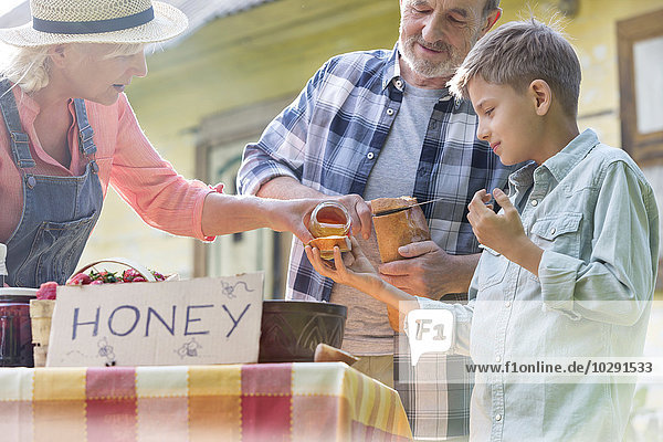 Verkostung und Verkauf von Honig durch Großeltern und Enkel am Bauernmarktstand
