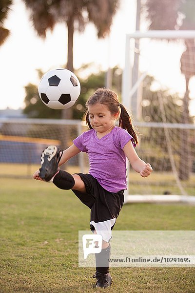 Mädchen treten Fußball auf dem Übungsplatz