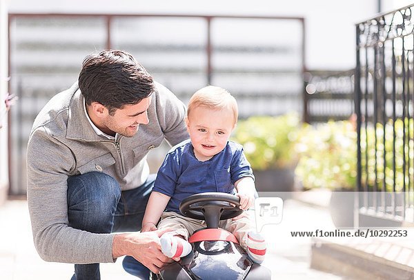 Vater und Sohn spielen zusammen  Sohn reitet Spielzeugauto
