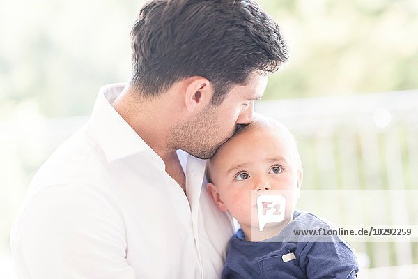 Vater küsst jungen Sohn auf den Kopf