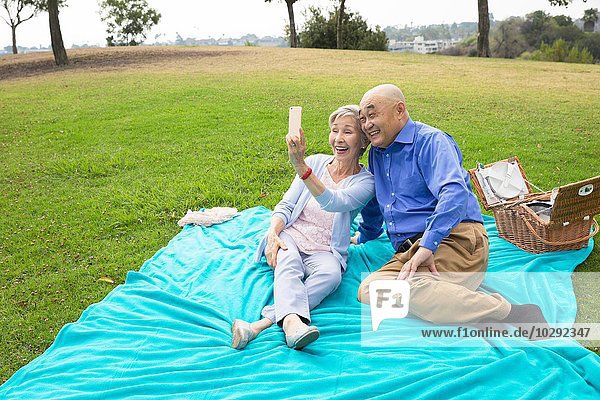 Seniorenpaar beim Picknick im Park  Selbstporträt mit dem Smartphone
