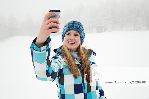 Young woman taking selfie in snow  Sattelbergalm  Tirol  Austria