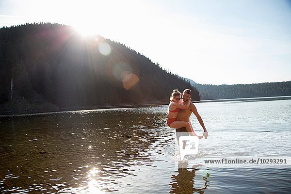 Young couple in lake  man carrying woman  Lost Lake  Oregon  USA