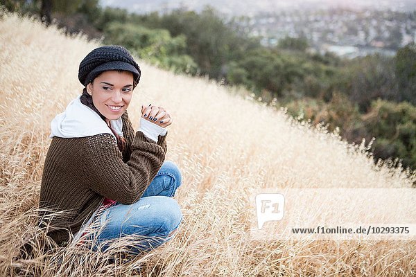 Portrait of young woman wearing a cap on grassy hill