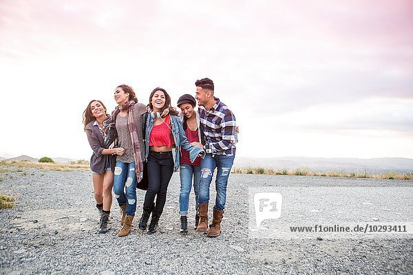Candid portrait of young man and four adult sisters on dirt track