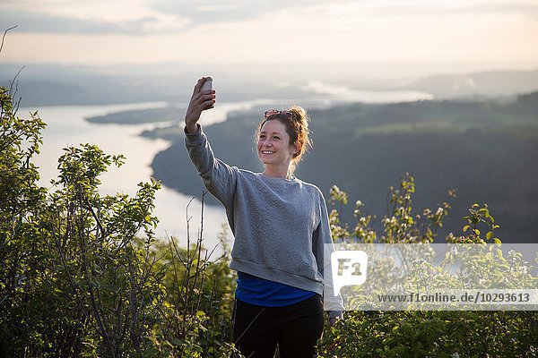 Woman taking selfie on hill  Angel's Rest  Columbia River Gorge  Oregon  USA