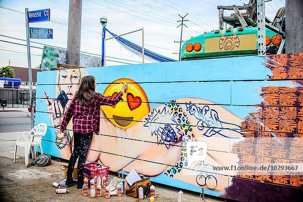 Graffiti artist spray painting wall  Venice Beach  California  USA